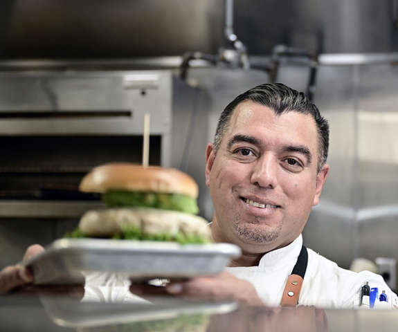 Chef putting a burger up in window to serve to customers