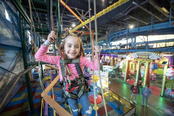 Girl smiling while conquering the high ropes course