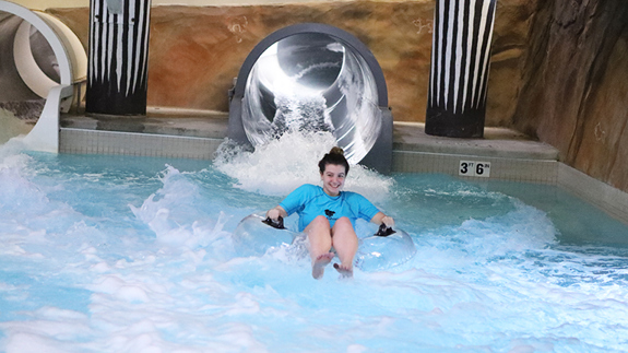 girl slide down the elephants trunk slide in the indoor waterpark