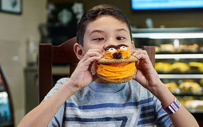 small boy eating a cookie sandwich at java manjaro