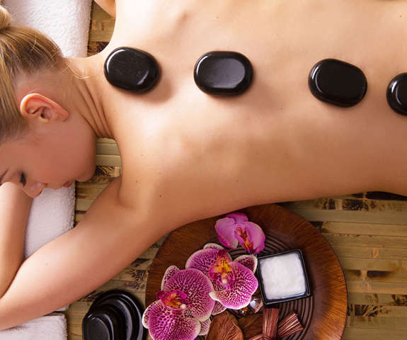 woman getting a hot stone massage in the spa
