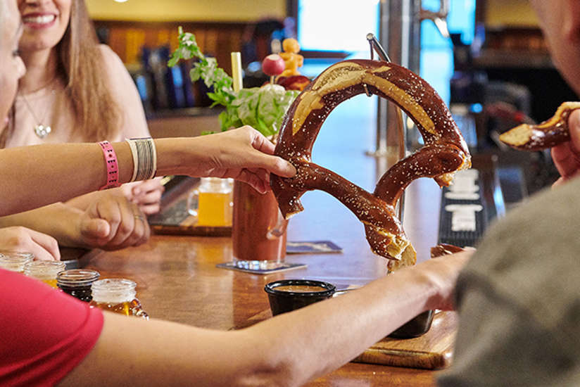 a group of friends sharing a giant pretzel at wisconsin brew pub