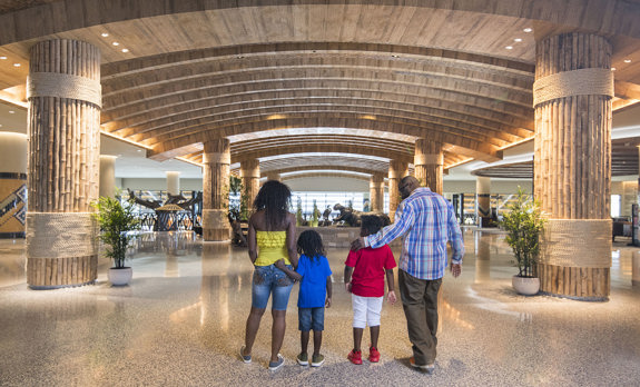 Family of four is entering Kalahari Resort entrance in Round Rock, Texas. Their backs are to us.
