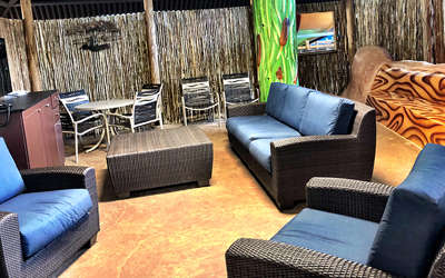 Overview of the Kids safari cabana. Includes table, chairs, tv, and a couch. It's very jungle kid-themed