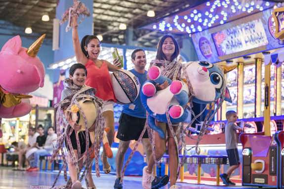 A family of four showing off the many tickets they won at Tom Foolerys Adventure Park