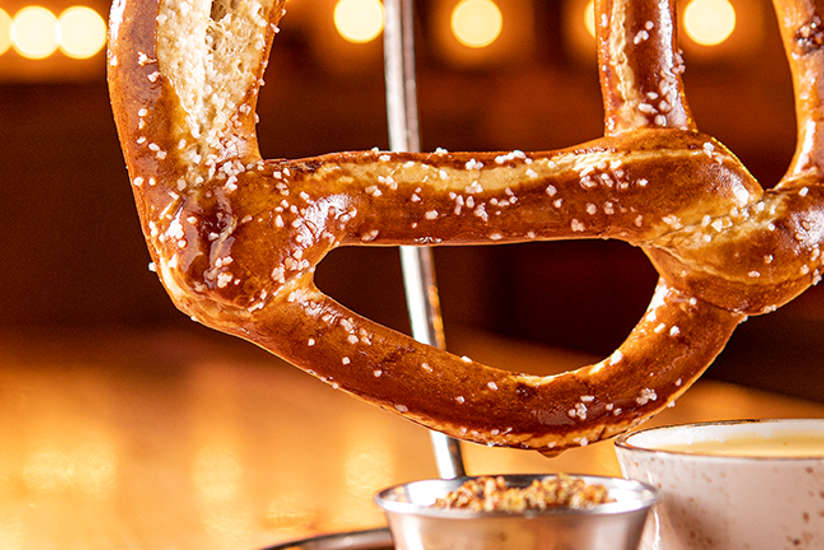 a giant pretzel and sauces from Blux Grill & Bar