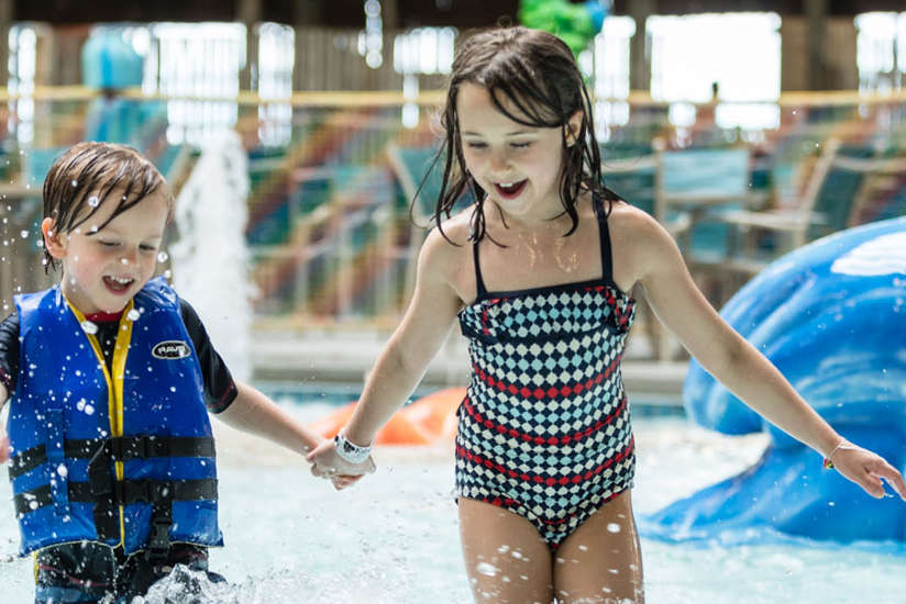 little boy and girl splashing in the waterpark