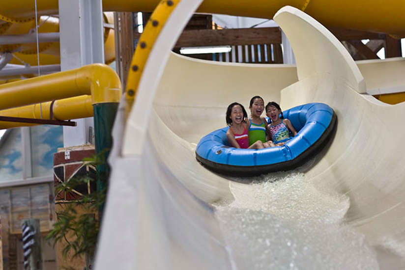 Three girls laughing on a water slide