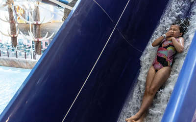 a young girl riding a water slide