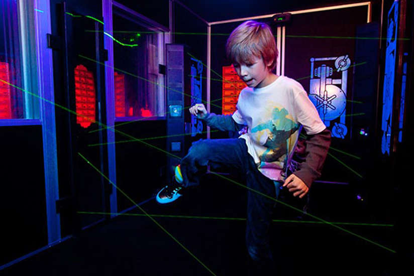 boy maneuvering his way through a laser maze