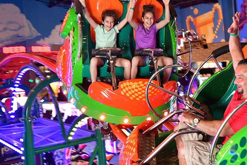 Family Riding the Scream'n Centipede Roller Coaster in Tom Foolerys Adventure Park