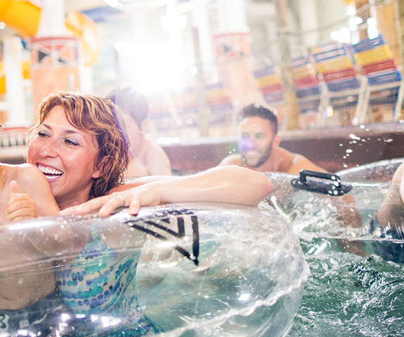 a family enjoying themselves and smiling floating down the lazy river