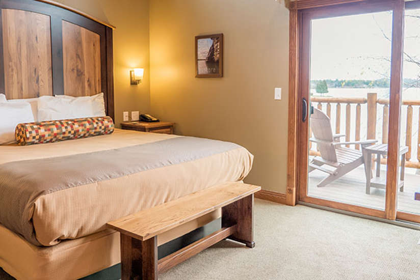 Cottage room with a king size bed and a glass sliding door showing the lake