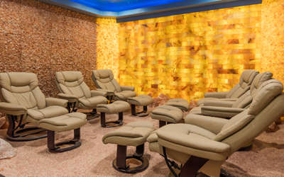 A himalayan salt halotherapy room with six leather chairs in it