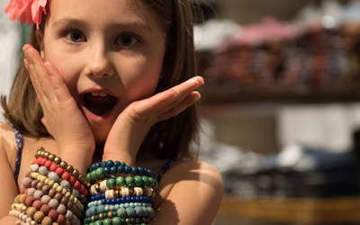 little girl making funny face while shopping for bracelets in marrakesh market