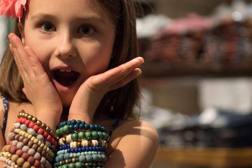 little girl making funny face while shopping for bracelets in marrakesh market