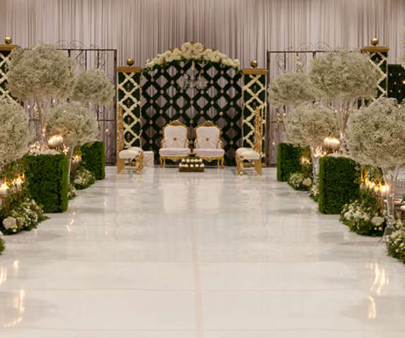 a beautiful wedding set up with large white floral trees, white and gold seating and candle light, inside Kalahari's Convention Center