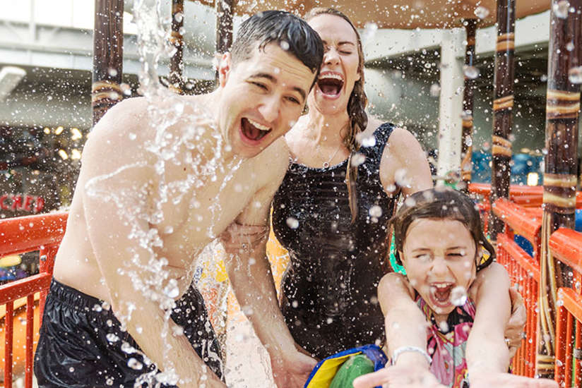 family playing in the play structure in the waterpark together