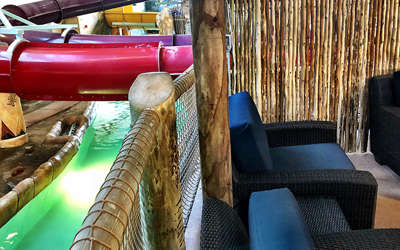 Overview of the Riverview cabana. Includes table, chairs, tv, and a couch. It's by the lazy river.