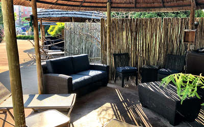 Overview of the outdoor bungalow. Includes table, chairs, tv, and a couch. It's outside!