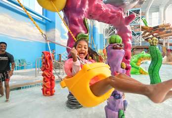 Girl Swinging in Coral Cove in the Indoor Waterpark