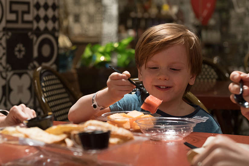 a boy eating some fruit at marrakesh market