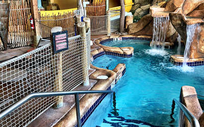an overview of the wave view cabana. It includes a tv, lots of chairs chairs, couch, private whirlpool oasis, and tables.