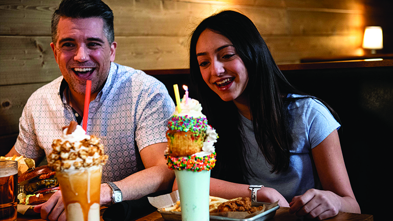 a family enjoying Fries, Shakes, and Sandwiches from Blux