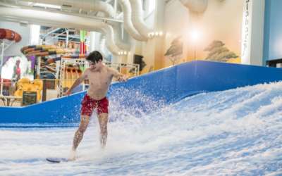 Person standing on a surf board in the FlowRider.