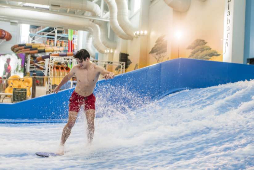 Person standing on a surf board in the FlowRider.