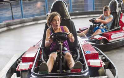 A girl and boy having fun racing the Meteorace Go Carts at Tom Foolerys Adventure Park.