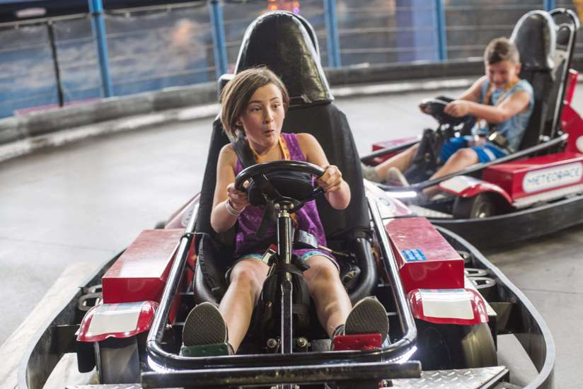 A girl and boy having fun racing the Meteorace Go Carts at Tom Foolerys Adventure Park.