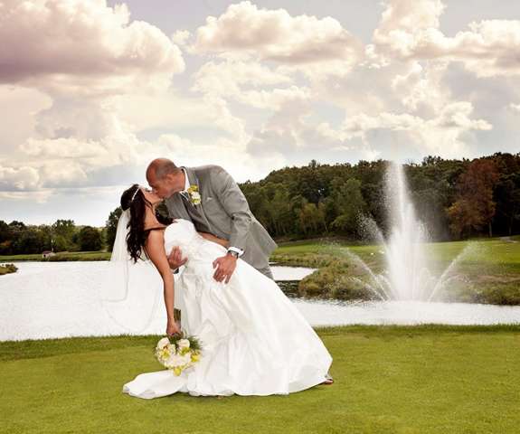 A wedding picture of the husband kissing the bride at the Trapper Turn Golf Course.
