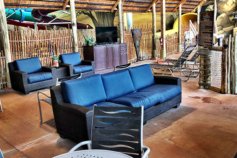 an overview of the wave view cabana. It includes a tv, lots of chairs chairs, couch, private whirlpool oasis, and tables.
