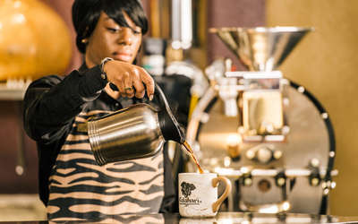 a woman pouring coffee at java manjaro