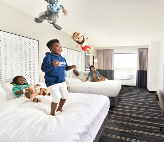 A young boy jumping up and down in bed.