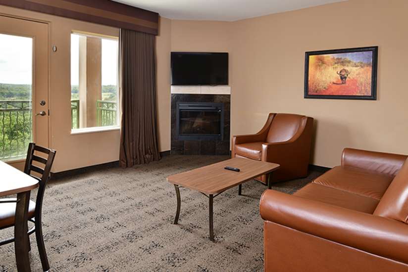 an overview of inside the African Queen Suite. Consists of a couch, chair, and dining area.