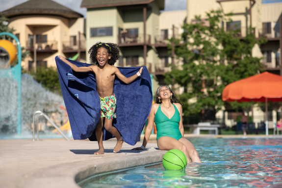 mom and son laughing by the pool