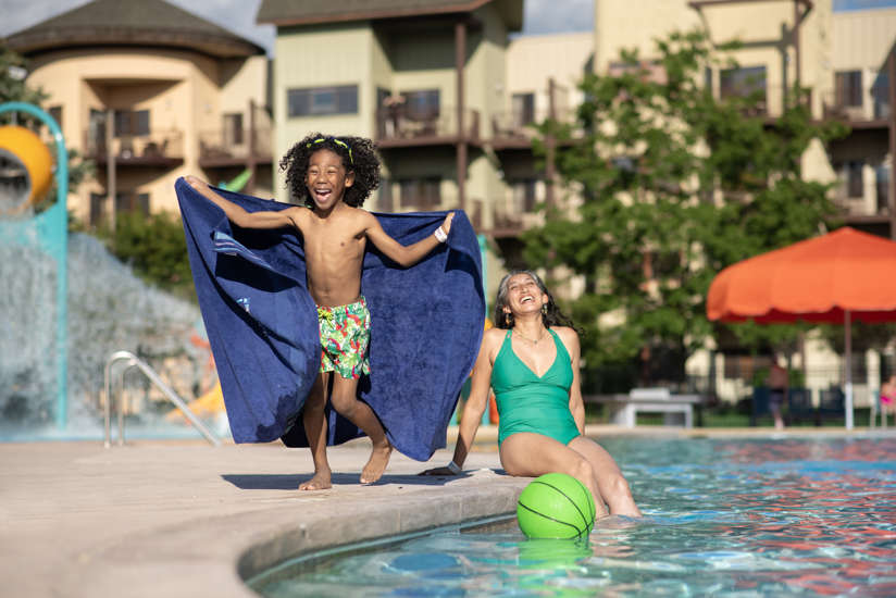 mom and son laughing by the pool