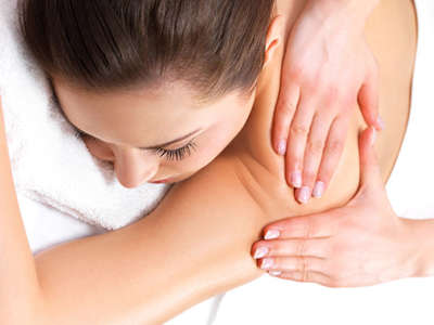 a woman laying on her stomach getting a massage in the spa