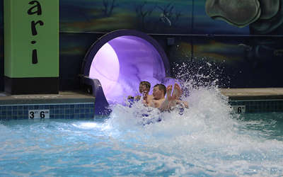 some friends sliding down the rippling rhino slide in the indoor waterpark