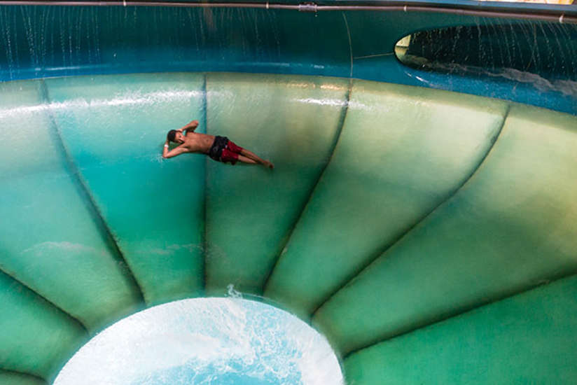 a young boy swirling around a water slide