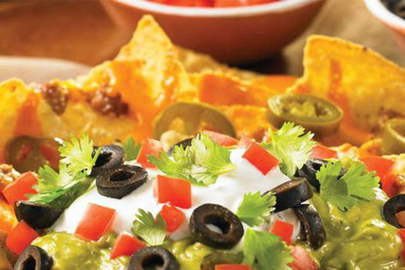 a plate of nachos with lots of toppings