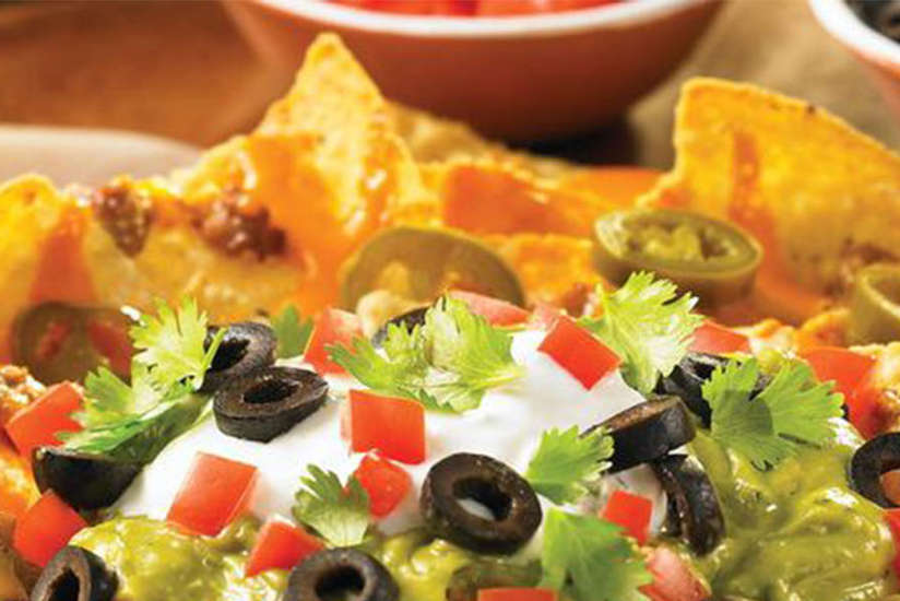 a plate of nachos with lots of toppings a plate of nachos with lots of toppings