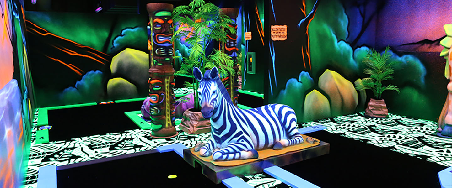 blacklight mini golf course with a laying down zebra sculpture