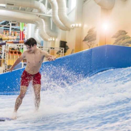 A guy having fun surfing the Flowrider. 