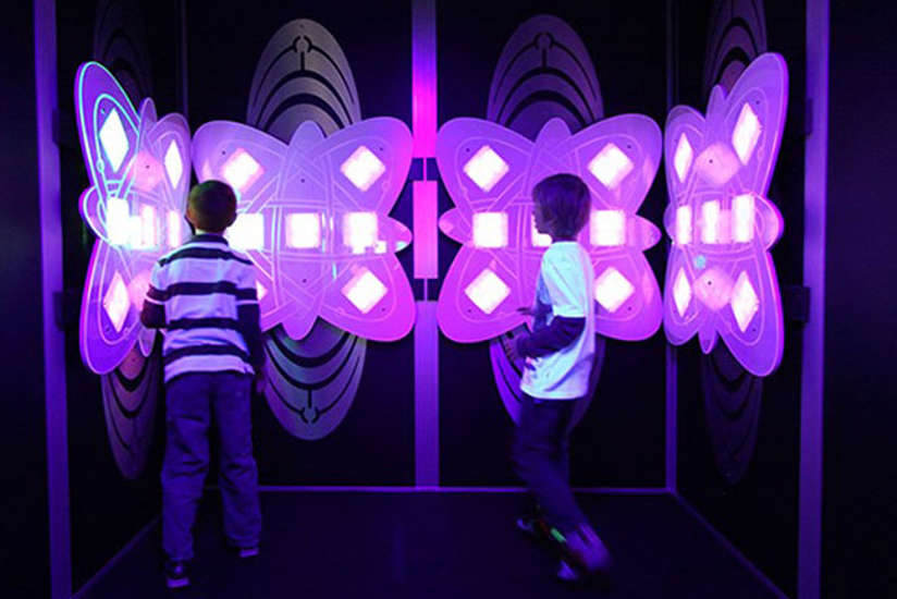 two kids playing with an interactive light game