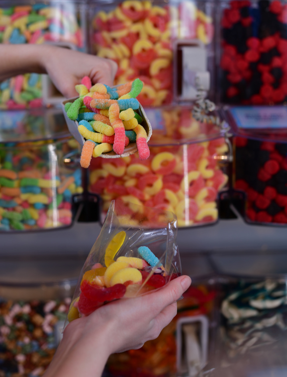 Scooping gummy worms into a treat bag