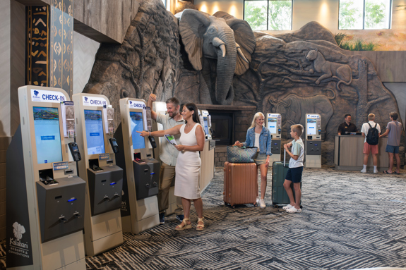 employee assisting family with kiosk check-in