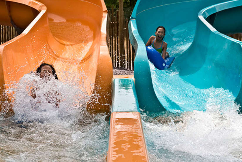 two girls racing down adjacent water slides